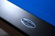 Close-up of the Doc & Holliday engraved nameplate on the end rail of the Poshy Reverse Rainbow Slate Pool Table, showcasing USA-made craftsmanship and modern black gloss finish. Close-up of the Doc & Holliday engraved nameplate on the end rail of the Poshy Reverse Rainbow Slate Pool Table, showcasing USA-made craftsmanship and modern black gloss finish.